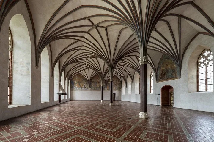 Spacious hall inside Malbork Castle with beautiful vaulted ceilings.