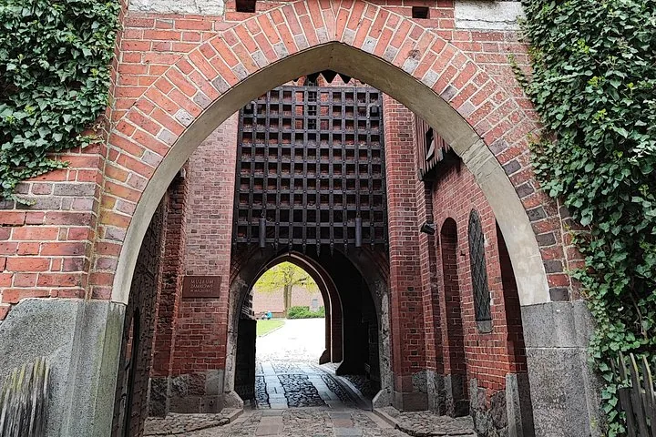 Arched brick gateway with a raised portcullis at Malbork Castle.